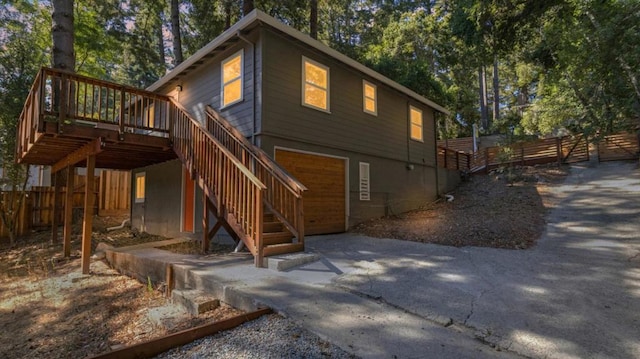 back of house featuring a garage and a wooden deck