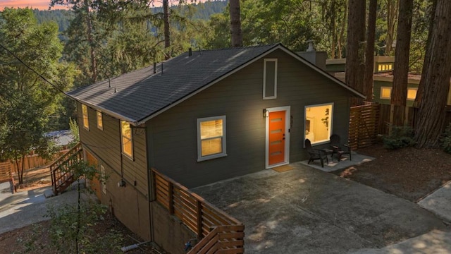 back house at dusk featuring a patio area