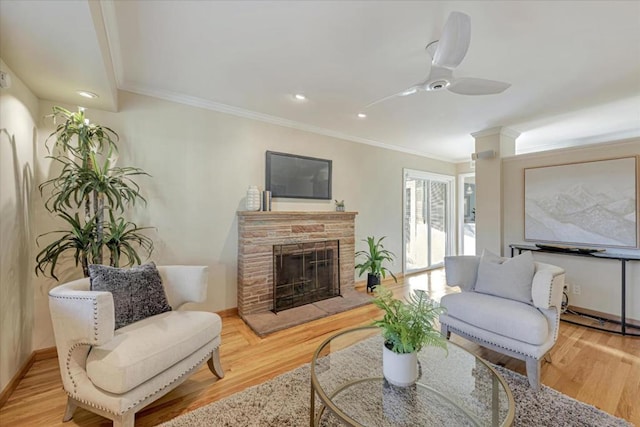 living room featuring ceiling fan, ornamental molding, and light hardwood / wood-style floors