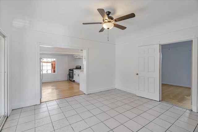 unfurnished living room featuring ceiling fan and light tile patterned floors