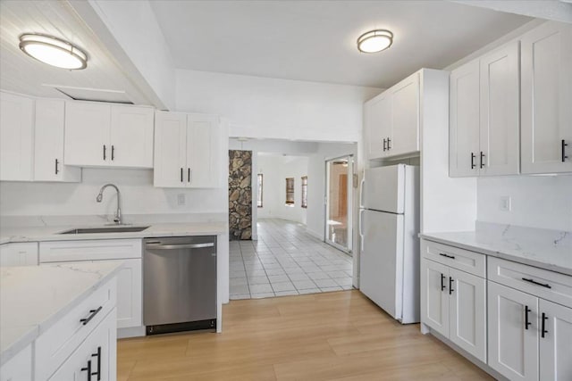 kitchen featuring white fridge, dishwasher, white cabinets, and sink