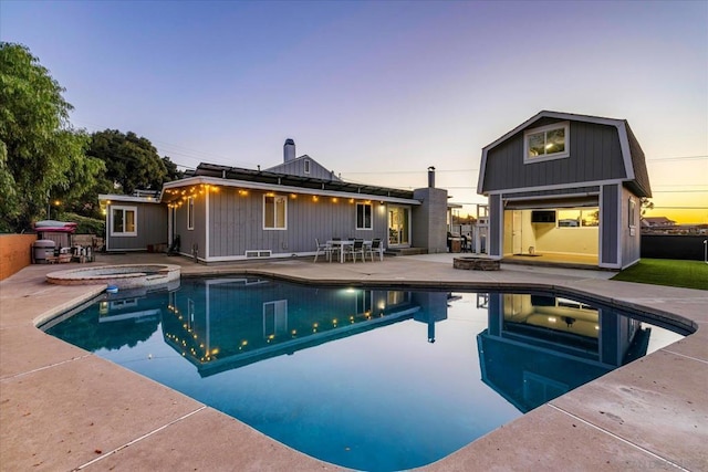 pool at dusk featuring an in ground hot tub, an outdoor fire pit, and a patio area