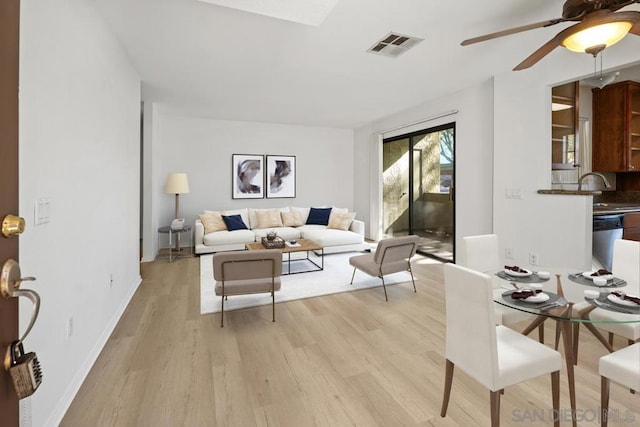 living room with sink, ceiling fan, and light hardwood / wood-style flooring