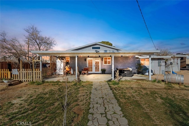 view of front of property featuring a patio area, french doors, and a lawn