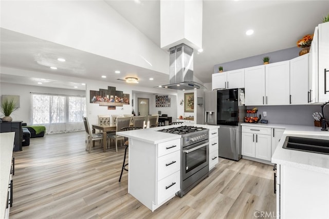 kitchen featuring island range hood, a kitchen island, white cabinetry, and stainless steel appliances