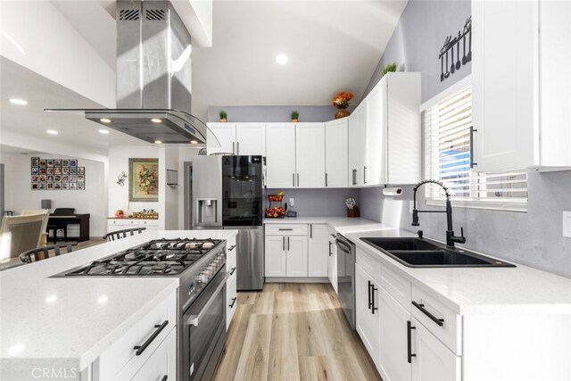 kitchen with island exhaust hood, appliances with stainless steel finishes, sink, and white cabinetry