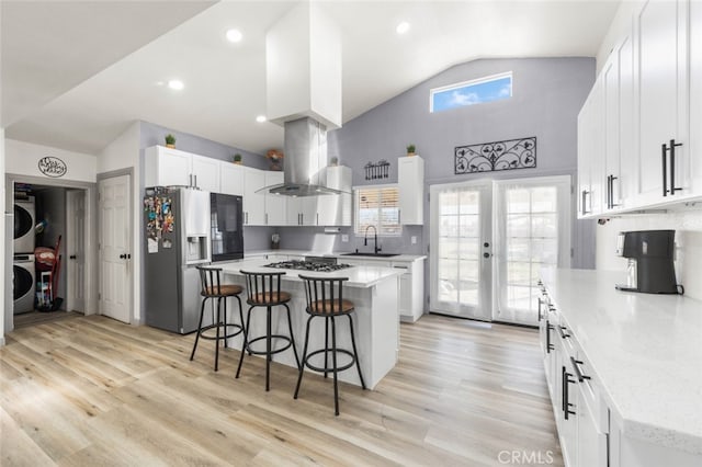 kitchen featuring white cabinetry, island exhaust hood, stainless steel appliances, a center island, and sink