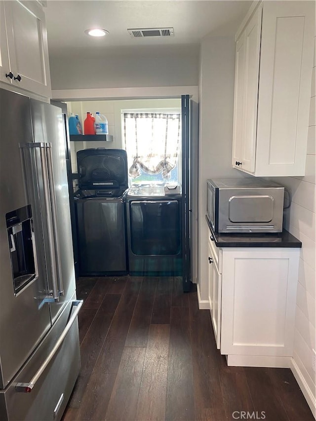 kitchen featuring white cabinetry, stainless steel appliances, dark hardwood / wood-style flooring, and separate washer and dryer