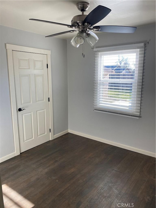 empty room featuring ceiling fan and dark hardwood / wood-style flooring