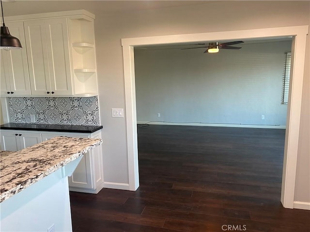 kitchen featuring ceiling fan, dark hardwood / wood-style floors, decorative backsplash, hanging light fixtures, and white cabinets