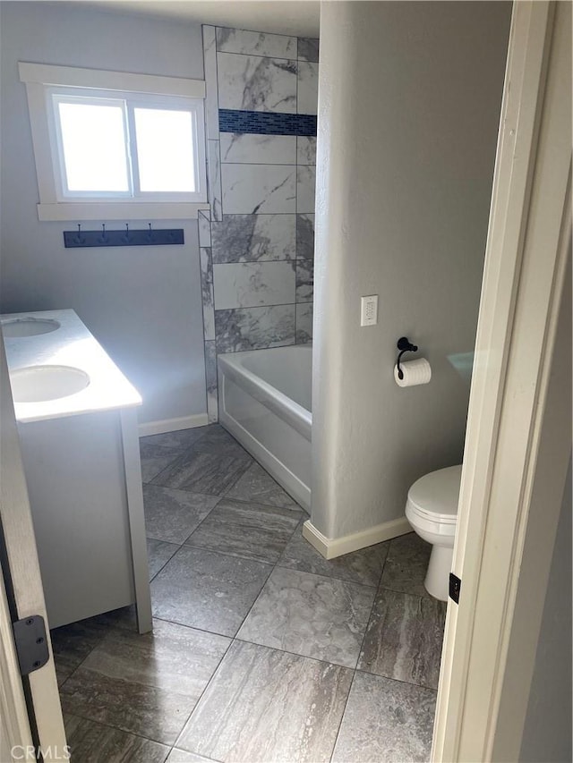 full bathroom featuring toilet, vanity, and tiled shower / bath