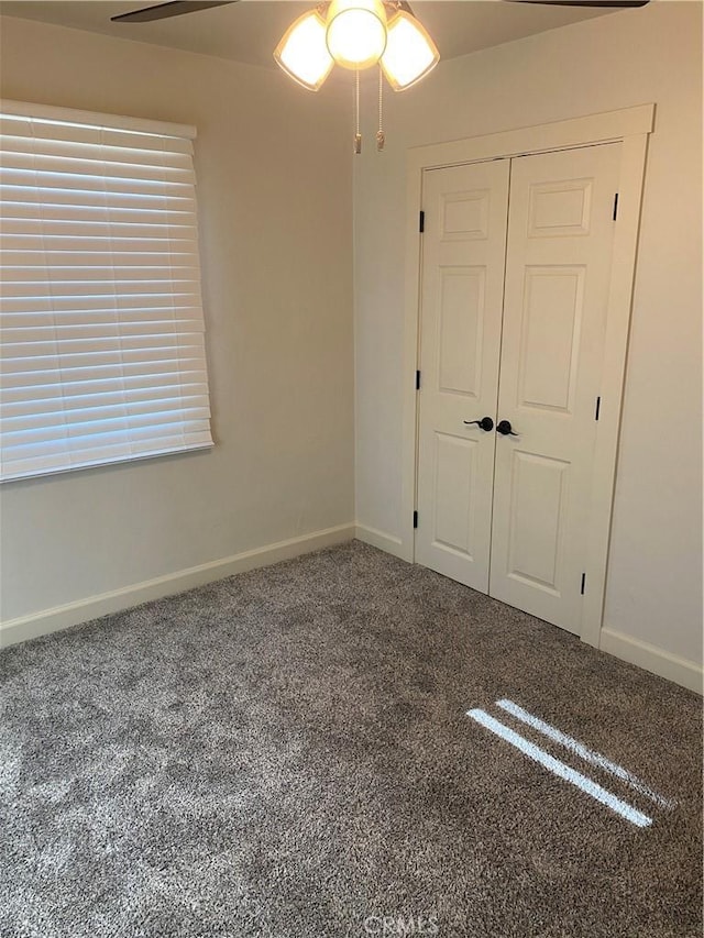 unfurnished bedroom featuring ceiling fan, a closet, and carpet floors