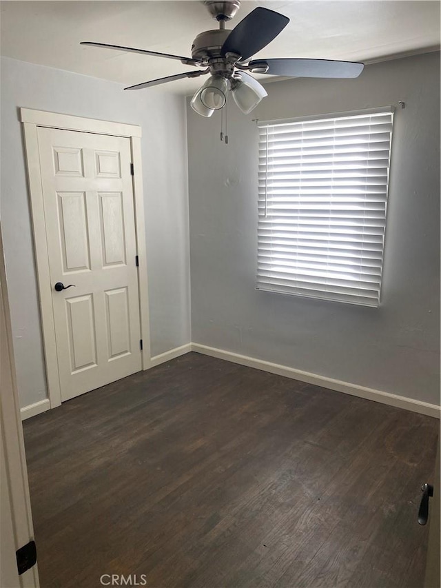 spare room with dark wood-type flooring and ceiling fan