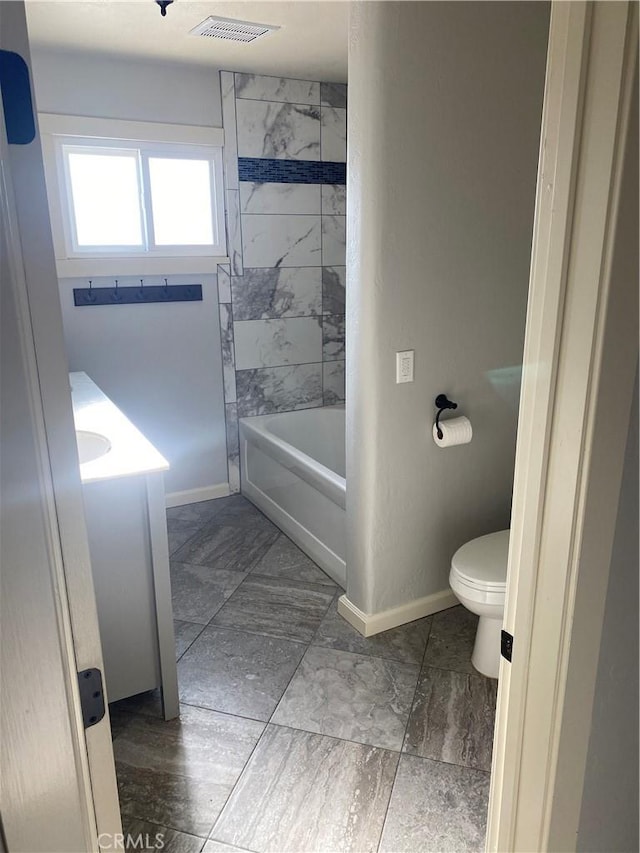 bathroom featuring toilet and tiled shower / bath