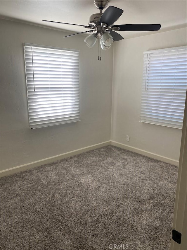 carpeted spare room with ceiling fan