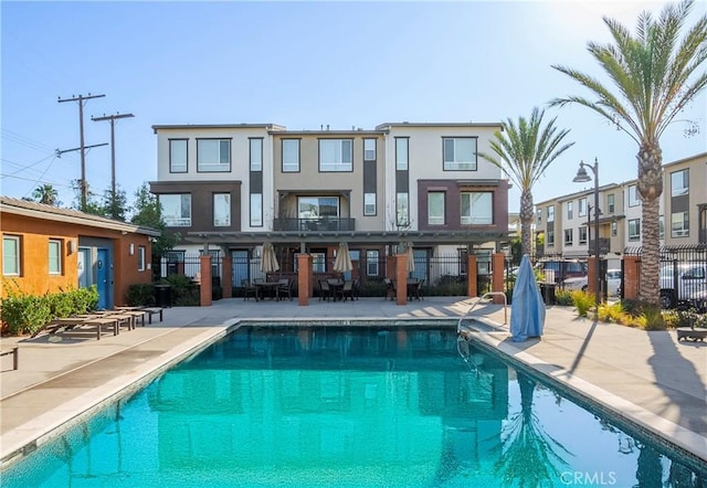 rear view of house with a patio area and a community pool