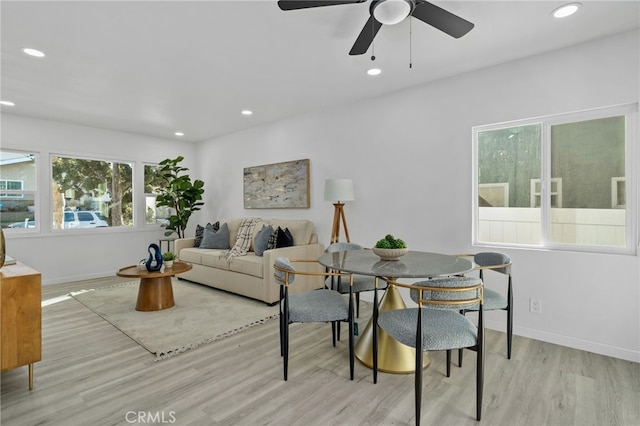 living room with ceiling fan, a healthy amount of sunlight, and light wood-type flooring