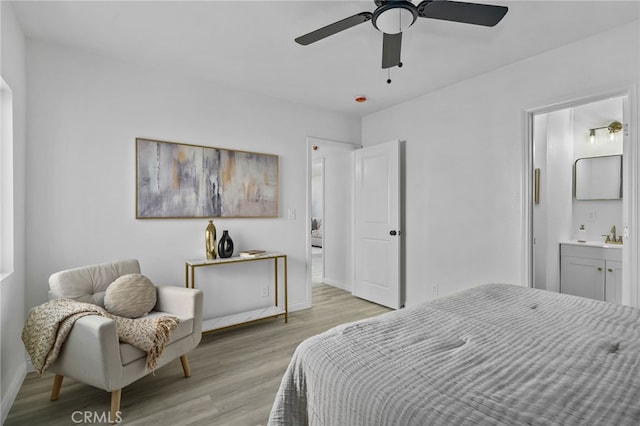 bedroom with ceiling fan, light hardwood / wood-style floors, and connected bathroom