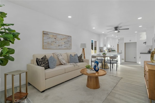 living room with ceiling fan and light hardwood / wood-style flooring