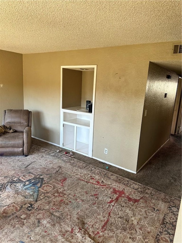 unfurnished living room featuring carpet floors and a textured ceiling