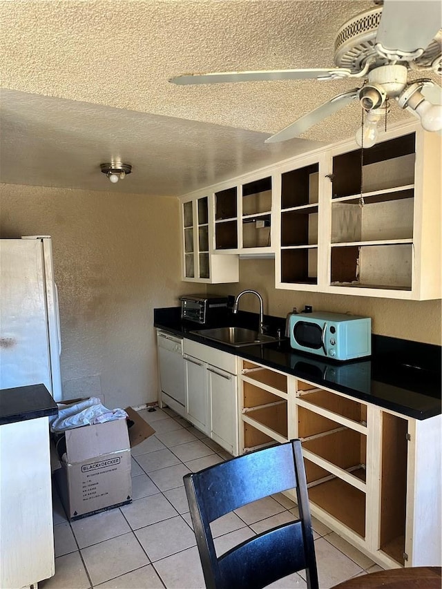 kitchen featuring white appliances, white cabinets, sink, ceiling fan, and light tile patterned floors