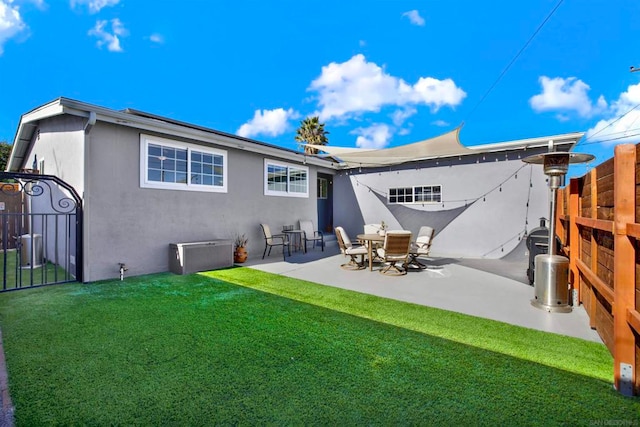 rear view of property with a lawn and a patio