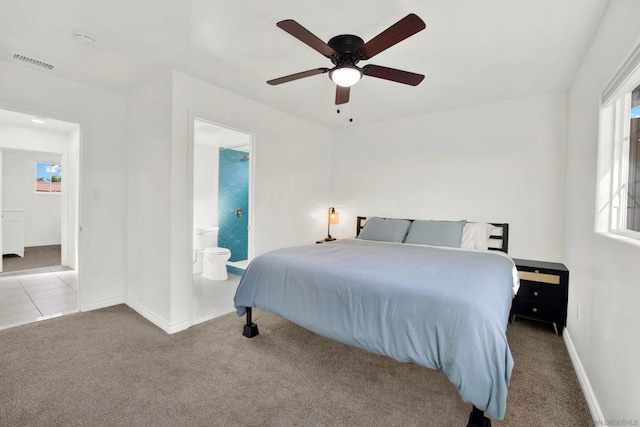 carpeted bedroom featuring ceiling fan and ensuite bath