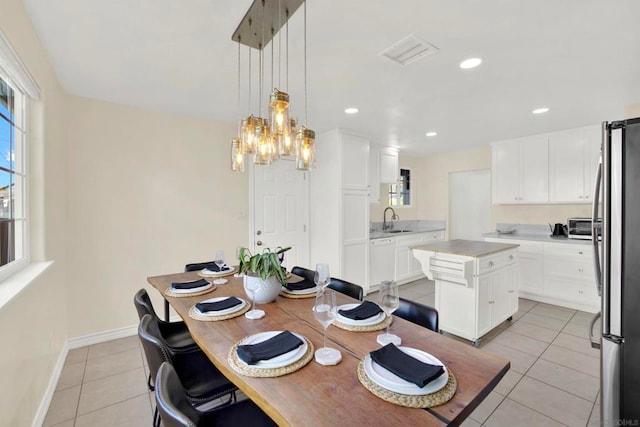 tiled dining room featuring sink and an inviting chandelier