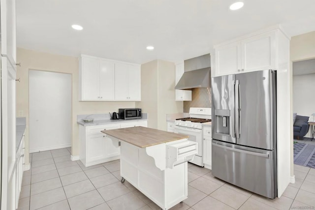 kitchen with wooden counters, stainless steel appliances, a kitchen island, wall chimney exhaust hood, and white cabinets