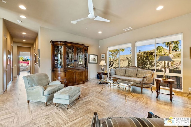 living room with ceiling fan, light parquet flooring, and a skylight