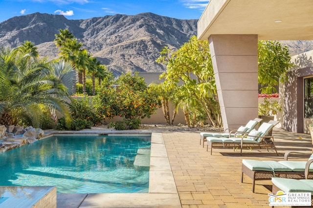 view of swimming pool featuring a mountain view and a patio area