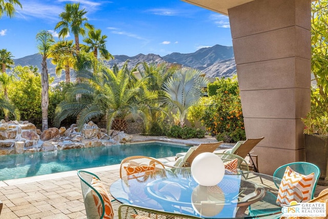 view of swimming pool with a mountain view and a patio area