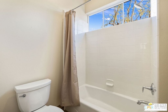 bathroom featuring shower / tub combo with curtain and toilet