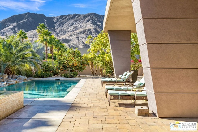 view of pool with a mountain view and a patio area