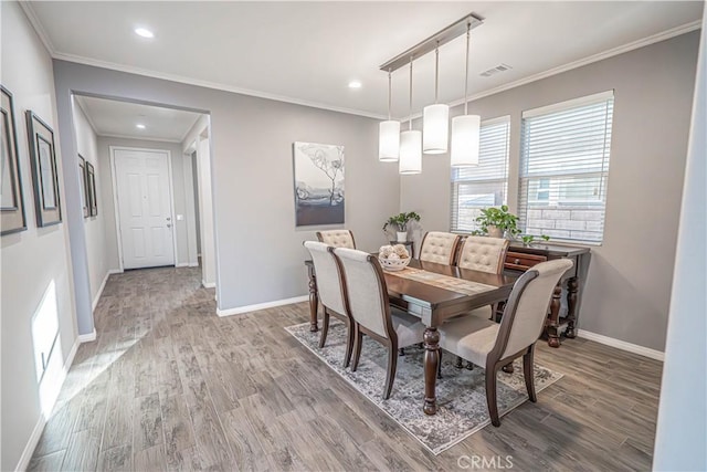 dining room with crown molding and wood-type flooring