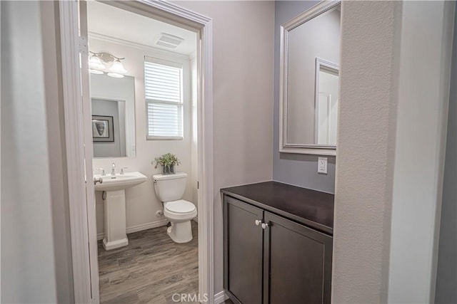 bathroom featuring hardwood / wood-style floors and toilet