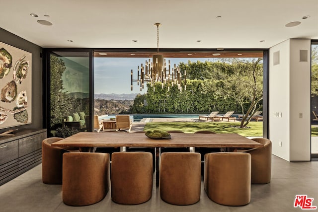 dining room with floor to ceiling windows, a notable chandelier, and a mountain view