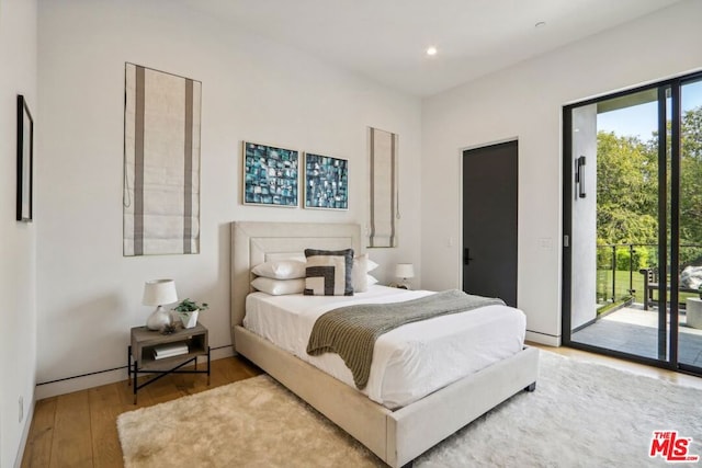 bedroom featuring hardwood / wood-style flooring and access to outside