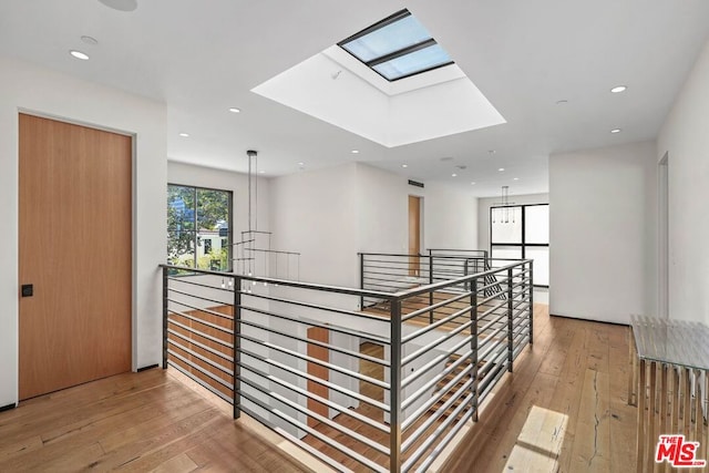 hall featuring light hardwood / wood-style flooring and a skylight