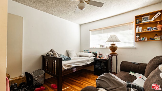 bedroom with wood-type flooring, a textured ceiling, and ceiling fan