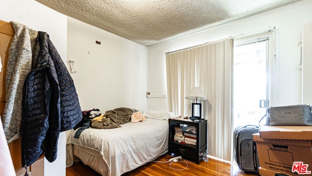 bedroom with a textured ceiling and hardwood / wood-style floors