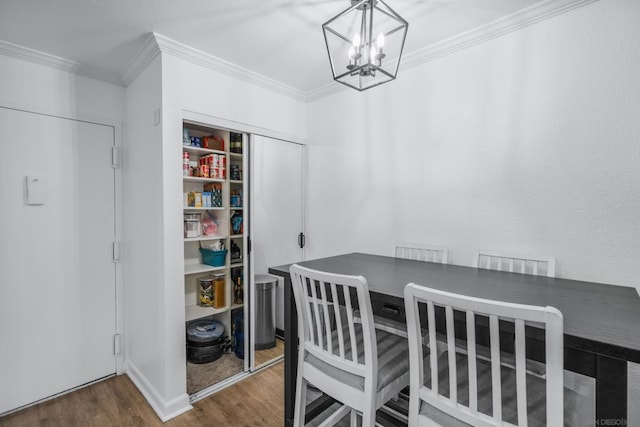 dining area with crown molding, dark wood-type flooring, and an inviting chandelier