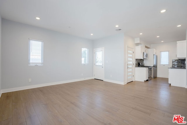 unfurnished living room featuring light hardwood / wood-style floors and plenty of natural light