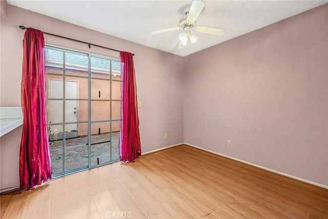 spare room featuring a textured ceiling, ceiling fan, and light hardwood / wood-style floors