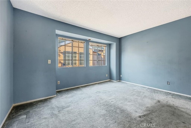 empty room featuring a textured ceiling and carpet