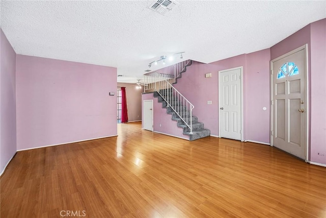 unfurnished living room featuring a textured ceiling, ceiling fan, and hardwood / wood-style flooring