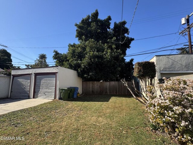 view of yard featuring a garage and an outdoor structure