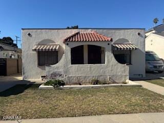 mediterranean / spanish-style home with a front lawn