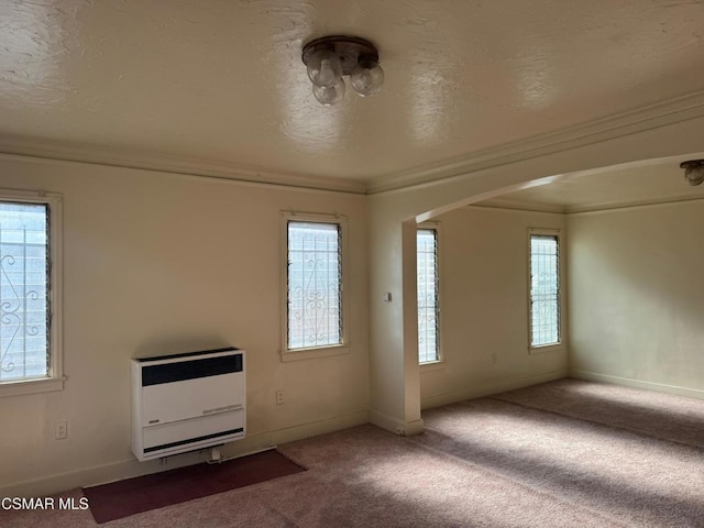 interior space featuring a textured ceiling, crown molding, and heating unit