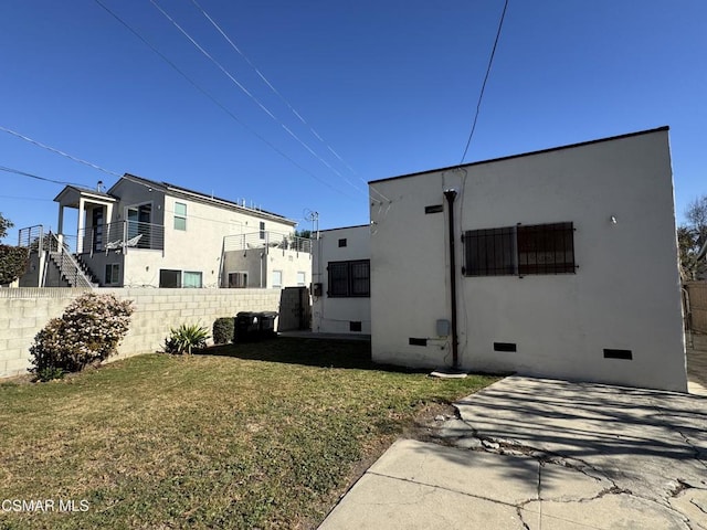 rear view of property featuring a patio area and a lawn